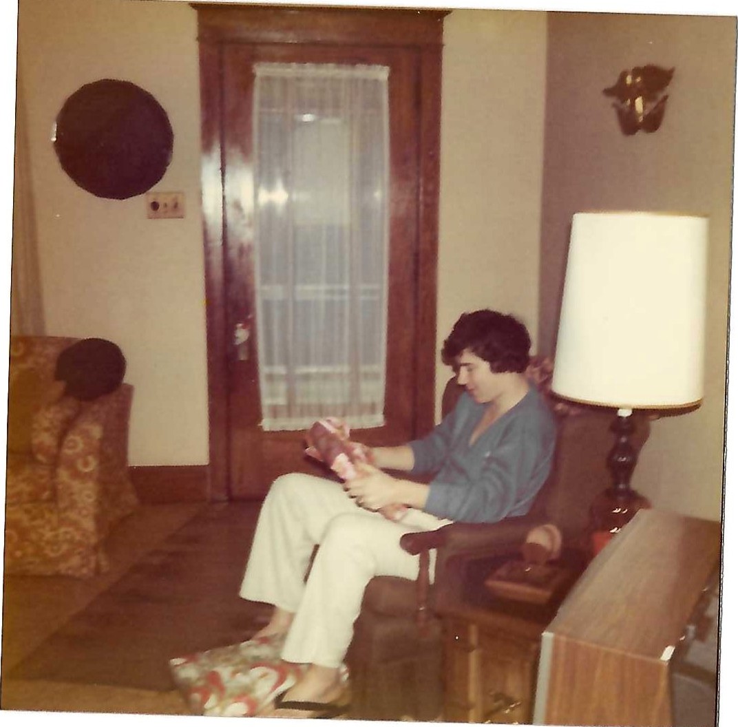 Young Paul opening a gift in a living room